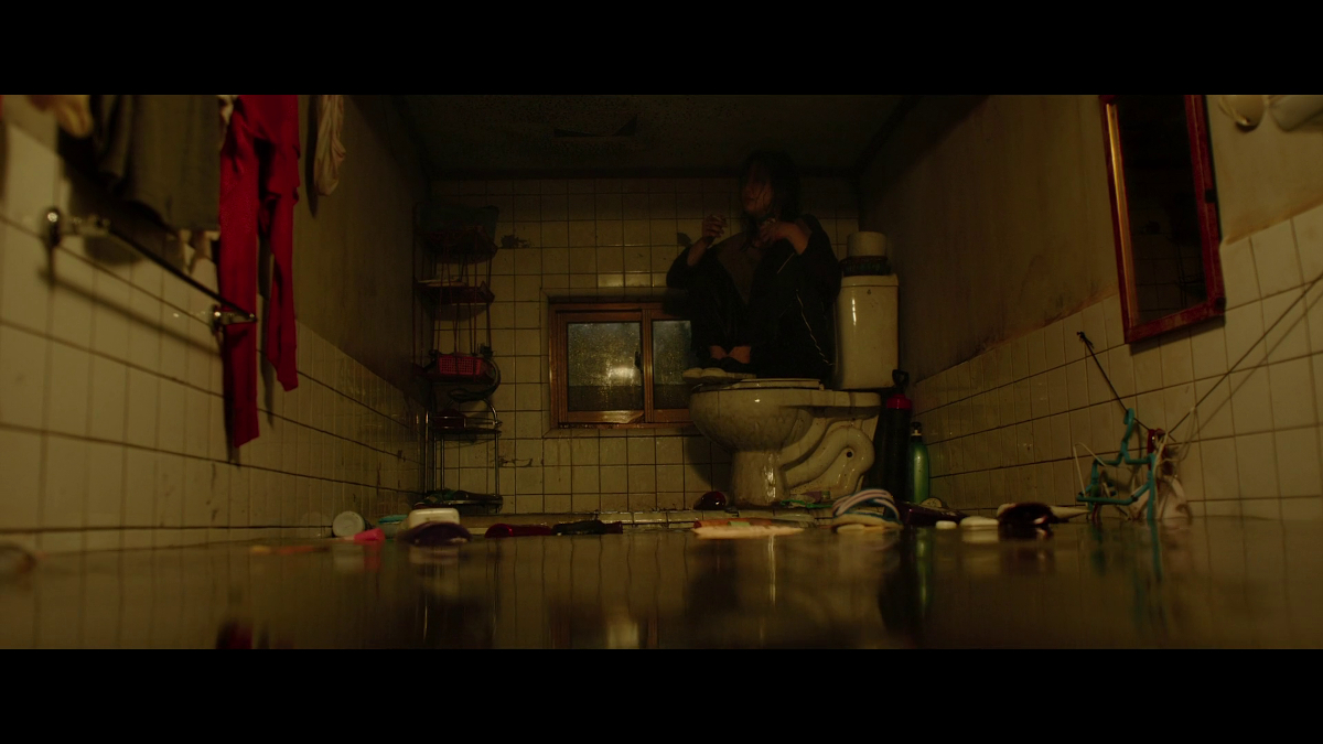 Ki-jung sitting on the toilet surrounded by a sea of sewage.
